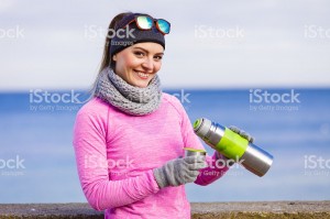 Fit woman in cold day warming up drink tea